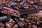 Close-up of dark roasted coffee beans and chocolate background. Aromatic coffee grains and sweet choco pieces macro photography