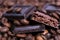 Close-up of dark roasted coffee beans and chocolate background. Aromatic coffee grains and sweet choco pieces macro photography