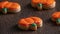 Close up of decorating cute Halloween pumpkin cookies with frosting in icing bag