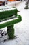 Close up of decorative piano on street in wintertime. Installation of green musical instrument with snow in winter