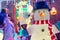 Close up Decorative snowman with lights and shiny outdoor Christmas decorations at night. Merry Xmas and New Year outside exterior