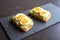 Close-up of delicious avocado toast topped with sliced boiled eggs and sesame seeds