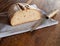 Close up of a delicious, crusty sliced bread on wood old table with knife