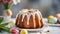 Close-up of delicious Easter bundt cake with white glazing on white table. Tasty holiday dessert