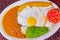 Close up of delicious ecuadorian food, rice, eggs, pplantains, avocado tomato served in a white plate over a wooden