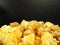 Close up of delicious popcorn isolated on black background. Include buttery caramel corn and rich cheddar cheese corn.