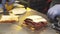 Close-up of a delicious sandwich with pastrami, pickles and cheese on the table. Making sandwiches in the kitchen