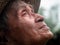 Close-up of a delighted Asian old man standing in a garden and facing the sky. Farmers are happy with the rain according to the