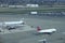 CLOSE UP: Delta passenger airplane taxiing past other planes being serviced.