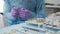 Close-up of a dental surgeon preparing a working tool for implanting a tooth to a patient.