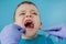 Close up of dentist`s hands with assistant in blue gloves are treating teeth to a child, patient`s face is closed