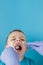 Close up of dentist`s hands with assistant in blue gloves are treating teeth to a child, patient`s face is closed