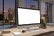 Close up of designer office desktop with empty white computer monitor, window with night city view, decorative items and supplies