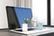 Close up of desktop with laptop and tiny shopping carts on keaybord. Blurry window with city view background. Online shopping and