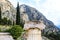 Close-up detail of broken ionic column in front of blurred rocky mountains behind at ancient Delphi Greece