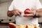 Close-up detail of Caucasian man`s hands cutting apples in the kitchen