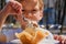 Close-up detail, child eating ice cream. Outdoor at the cafe