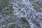 Close up detail of fierce white water river rapids from a clean deep green colored river forming a textured background