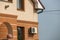 Close-up detail front stucco wall of big modern expensive residential family cottage with air conditioner on blue sky background.