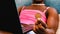 Close-up detail of a hand holding a Bitcoin coin of a black transgender person while shopping online