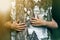 Close-up detail of isolated growing big strong tree trunk embraced from behind by small white child hands on blurred background.