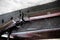 Close up detail of old flintlock rifle or musket, hanging on an old oak beam