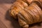 Close up / detail of a pair of French croissants on natural wood background