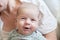 Close-up detail portrait of cute little peaceful smiling baby boy face