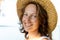 Close-up detail portrait of young adult caucasian happy brunette woman wearing straw hat enjoy smiling outdoors. Female