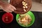 Close-up detail shot of Caucasian man adding apple inside a bowl with a preparation