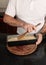 Close-up detail shot of Caucasian man`s hands placing, in a baking dish, the preparation to cook an apple pie