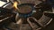 Close up detail shot of old rusty kitchen stove ring switched on fire with lighter flame burning in dangerous gas energy and