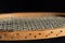 Close-up and detail shot of an old wooden tennis racket in front of dark background