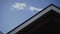 Close-up, detail of triangular roof of building against blue sky on sunny day