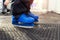 Close-up detail view of little kids leg wearing blue plastic rental skating boots standing on non-slip rubber soft mat