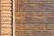 Close-up detail of wall covered with wooden siding. Part of automatic garage door . Car storage building facade part