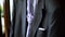 Close up detail of wedding male black suit with purple tie prepared for the groom. Action. Stylish dark men suit with a