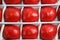 Close up detailed top view background wallpaper shot of rows and lines of large tasty red ripe tomatoes in a white crate box