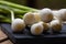 Close up of details of fresh green onions (scallion) on a cutting board isolated