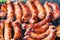 Close up on details of homemade sausages on barbecue grill. Barbecue, grill and food concept