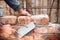 Close up details of industrial bricklayer installing bricks on construction site