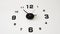 Close-up of a dial analog wall clock on a white wall