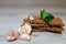 Close-up dietary loaves lying on each other decorated with fresh herbs and a bunch of garlic on a grey wooden table. Dry snacks di