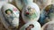 Close-up of different drawings on goose eggs for Easter festival. Eggs on hay. Hand made print. Spring hollidays. Easter