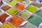 Close-up of different types of colored oriental spices and seasonings on market in square forms with price tags