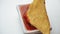 Close up dipping tortilla chips in salsa sauce. selective focus corn chips