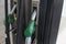 Close up on dirty fuel nozzle in oil dispenser with gasoline and diesel in service gas station. Pattern petrol pump gun
