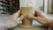 Close-up of dirty hands shaping clay into bowl on potter`s wheel working indoors