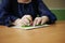 Close-up of disability blind person woman hands writing braille text on paper by using slate and stylus tools making embossed