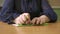 Close-up of disabled blind person woman hands writing braille text on paper by using slate and stylus tools making embossed